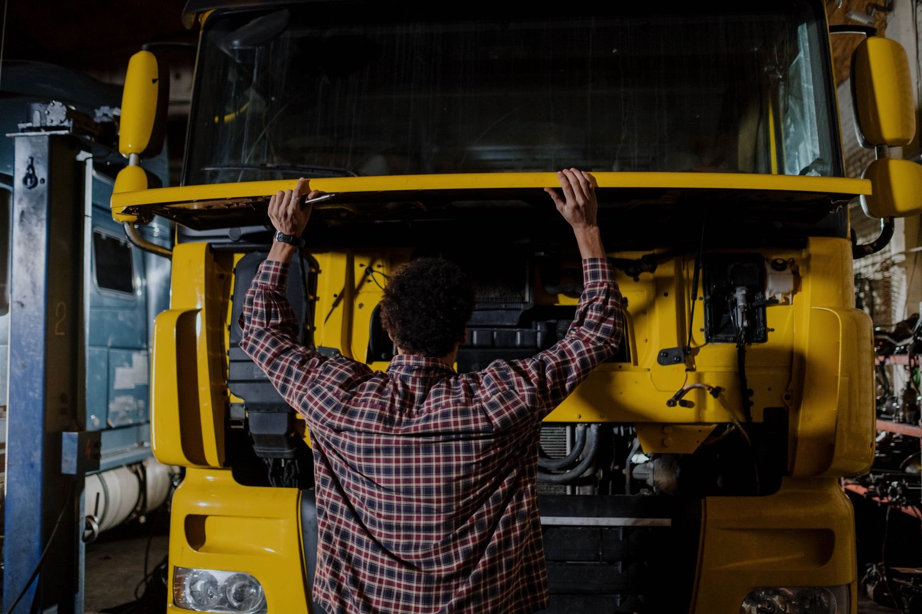 Mechanic inspecting a heavy truck engine in a workshop — representative of the technical diagnostic work CYPAK carries out